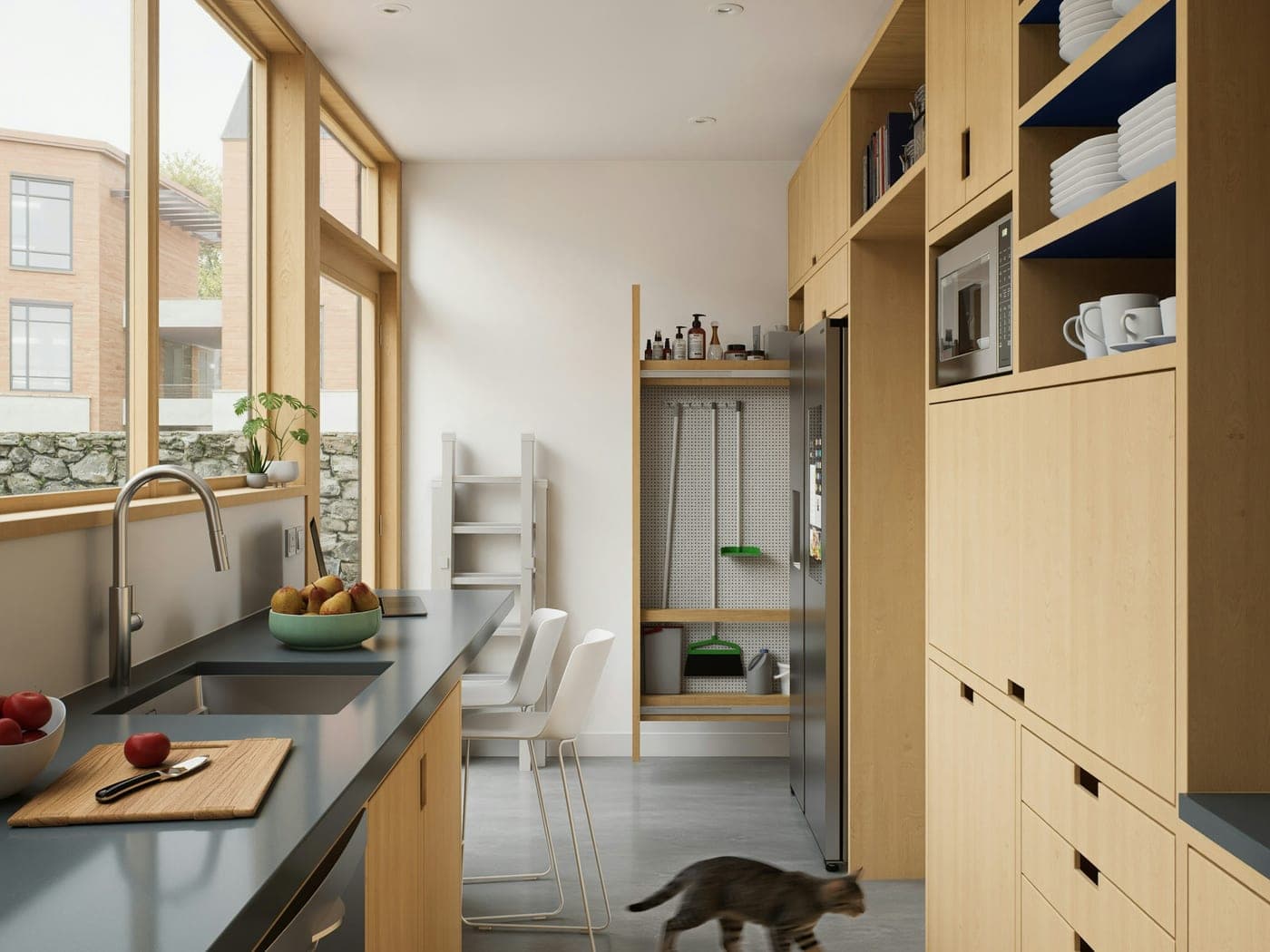 A cat walking across the floor of a bright kitchen with pale wood cabinets and a long counter